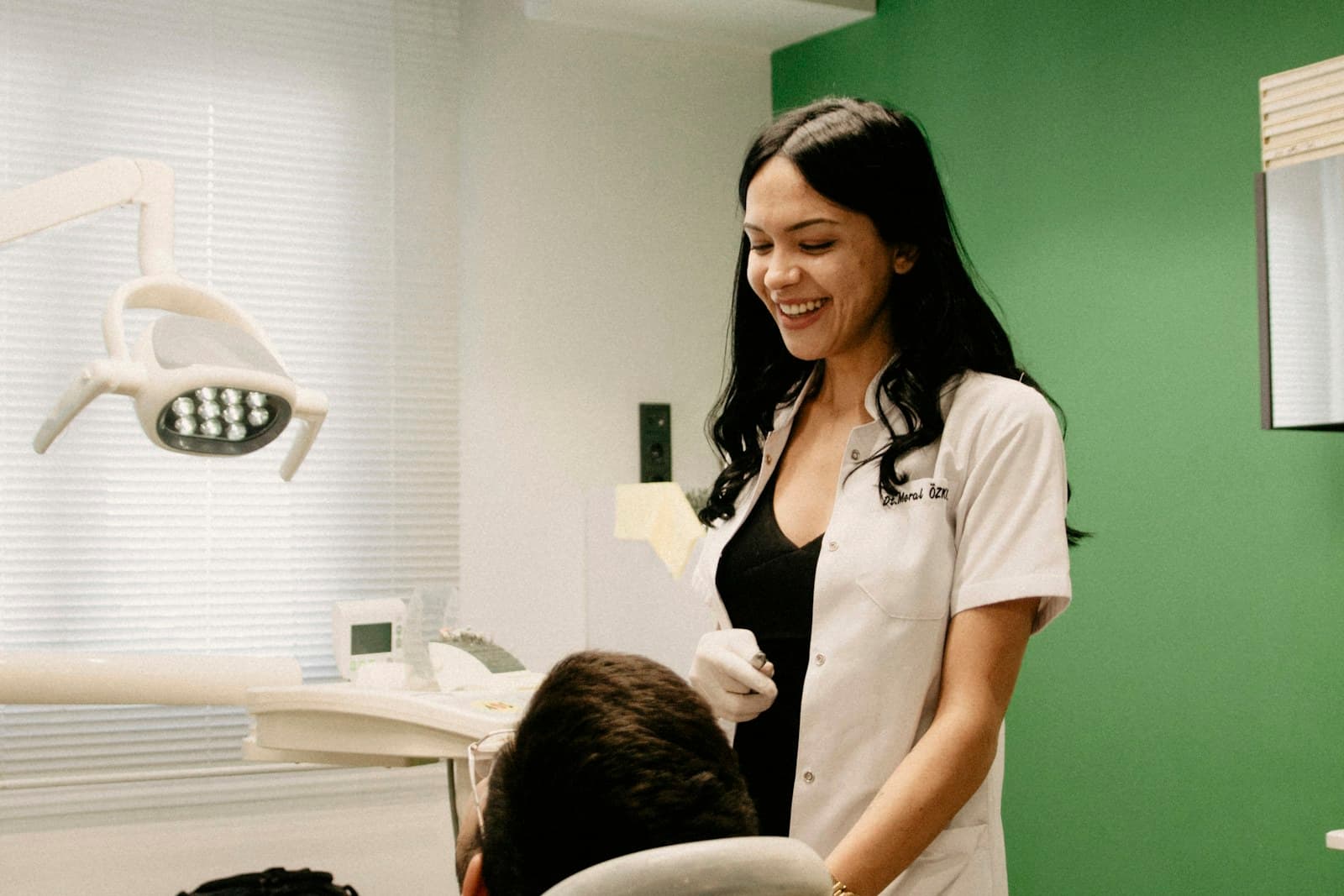 A Saltwater Dental clinician mid-conversation with a patient beside the chair, both at ease