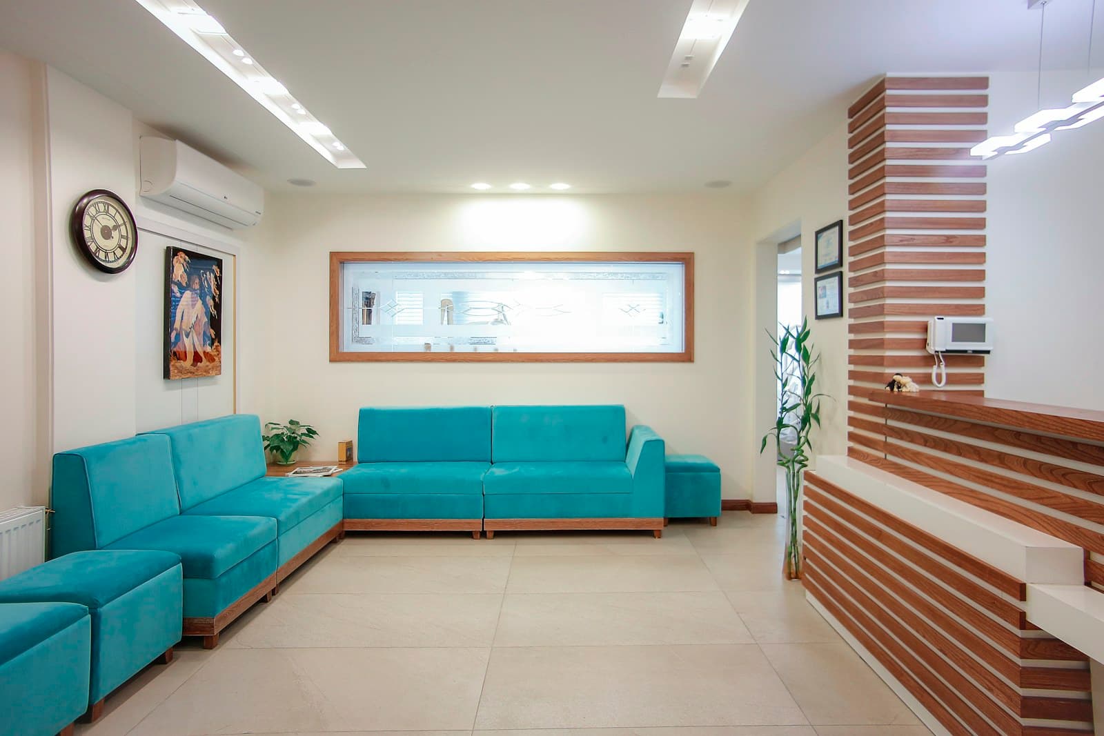 The waiting corner at Saltwater Dental with a low sofa against exposed brick and natural light