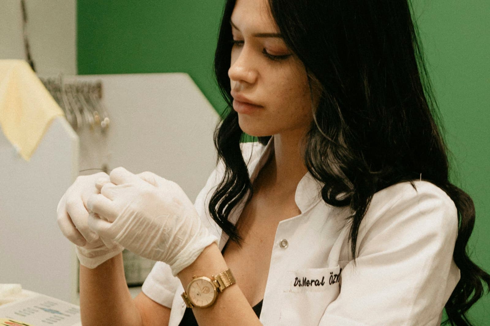 A clinician’s gloved hands preparing an instrument at the chairside